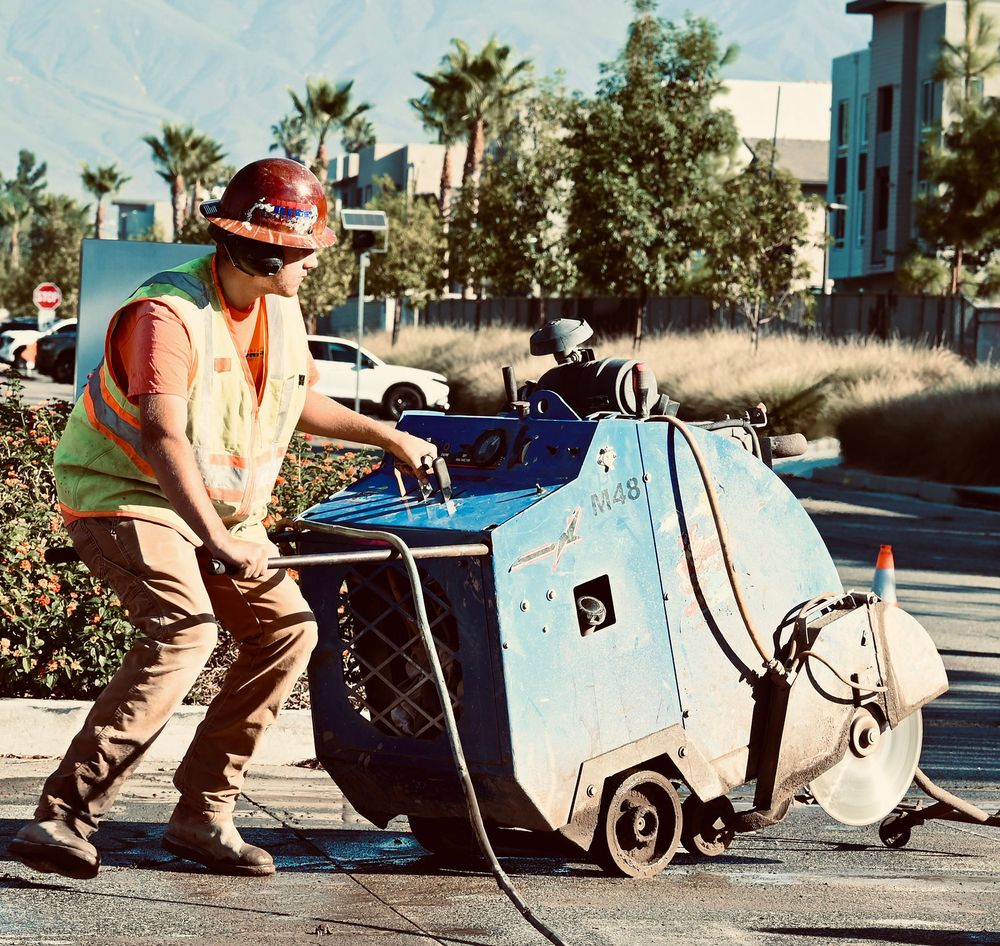 Operator flat-sawing along a curb with the blade in the pavement