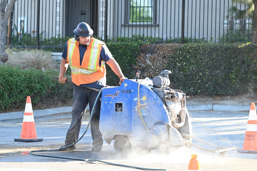 Operator flat-sawing pavement between traffic cones