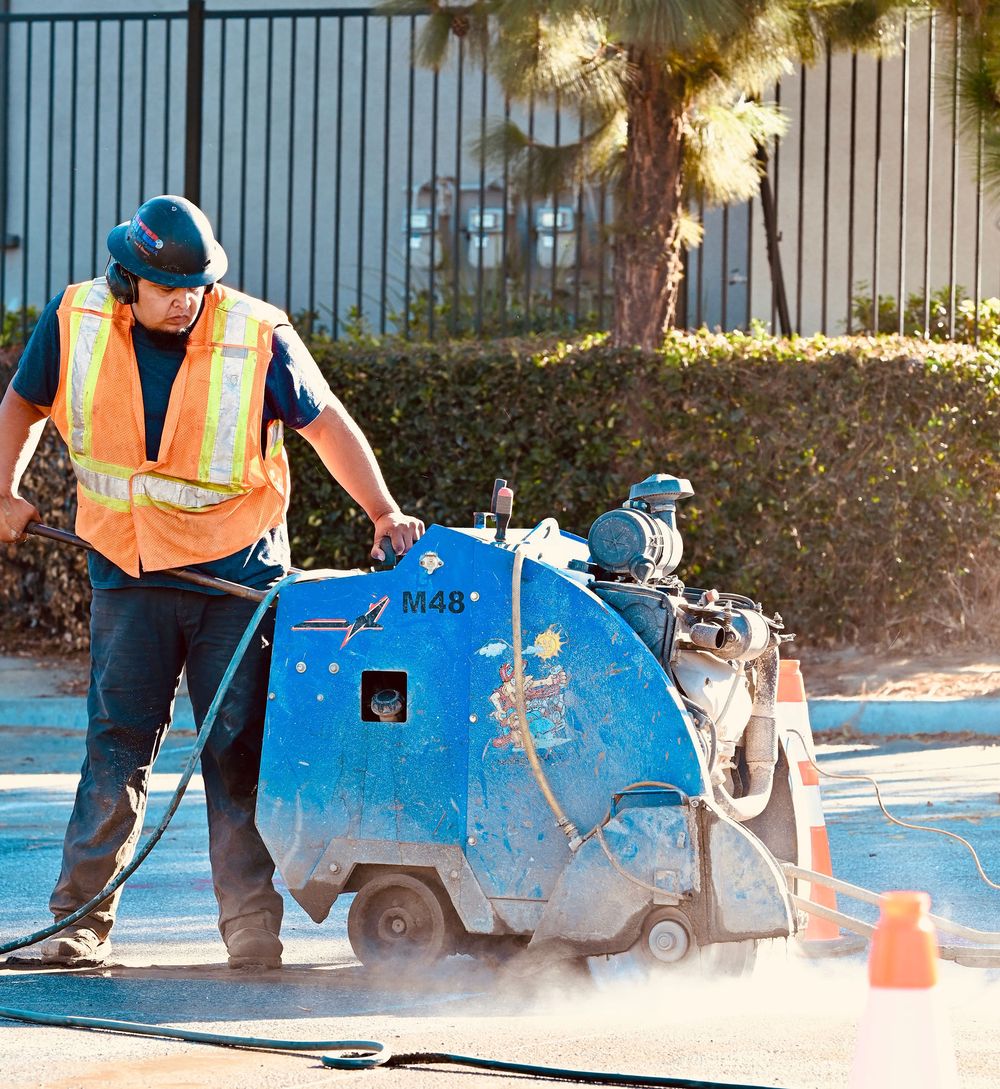 Operator running a flat saw as dust rises from the blade